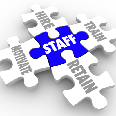 Staff Word on a puzzle piece and others connected to it with terms hire, train, motivate and retain to illustrate human resources challenges